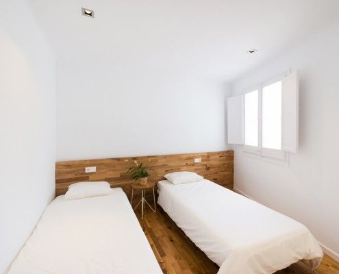 Double bedroom with wooden headboard - Full renovations in Girona by Estudio Romanelli
