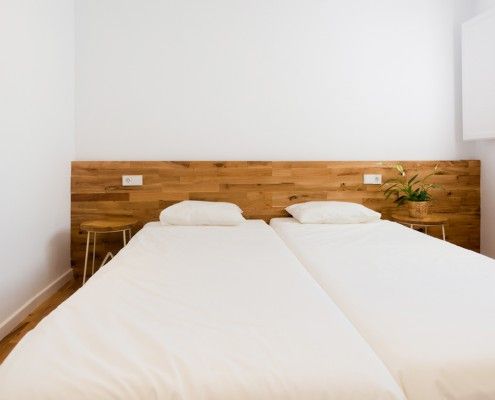 Bedroom with wooden headboard - Estudio Romanelli Girona