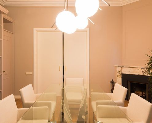 Vista mesa de reuniones Cattelan italia con y sillas tapizadas en blanco